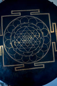 Load image into Gallery viewer, Divine Shri Yantra Gong with golden symbolic geometry mandala design on a dark aged metal surface, held by hand for sound practice and quiet listening use.