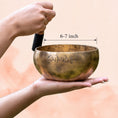 Load image into Gallery viewer, Full Moon Singing Bowl held in hand with wooden mallet, shown in a calm meditation setting.
