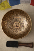 Load image into Gallery viewer, Om Mandala carved singing bowl with central Om symbol, detailed floral mandala engraving, repeated Om motifs, and wooden striker.