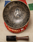 Load image into Gallery viewer, Buddha carved Singing Bowl for Heart and Root Chakra with inner Buddha artwork, red cushion and wooden mallet.