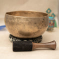 Load image into Gallery viewer, Kopre Singing Bowl for Crown and Root Chakra with aged brass finish, black cushion and wooden mallet