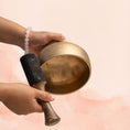 Load image into Gallery viewer, Naga Singing Bowl for Root Chakra with antique brass finish, held in hand with wooden mallet