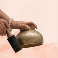Load image into Gallery viewer, Naga Singing Bowl for Sacral Chakra with aged brass finish, shown in hand with wooden mallet