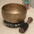 Load image into Gallery viewer, Thadobati Singing Bowl for Throat and Root Chakra with aged brass finish, black cushion and wooden mallet