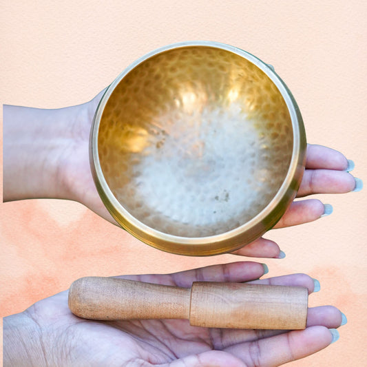 Hand Hammered Singing Bowl interior shown in hand, highlighting the smooth golden surface.