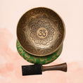 Load image into Gallery viewer, Om Mandala carved singing bowl with central Om symbol, detailed floral mandala engraving, repeated Om motifs, green cushion and wooden striker.
